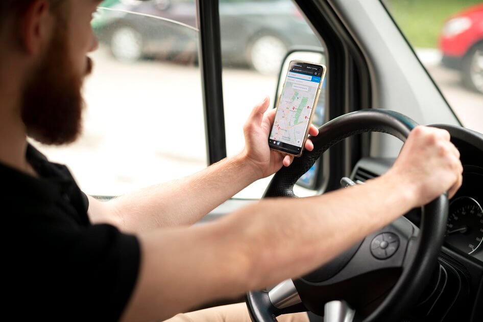 Motorista visualizando rastreamento veicular pelo celular em tempo real